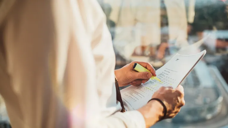 Person holding some papers and a marker