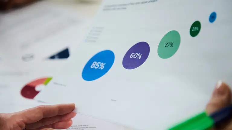 A person holding a piece of paper with circles and percentages on it